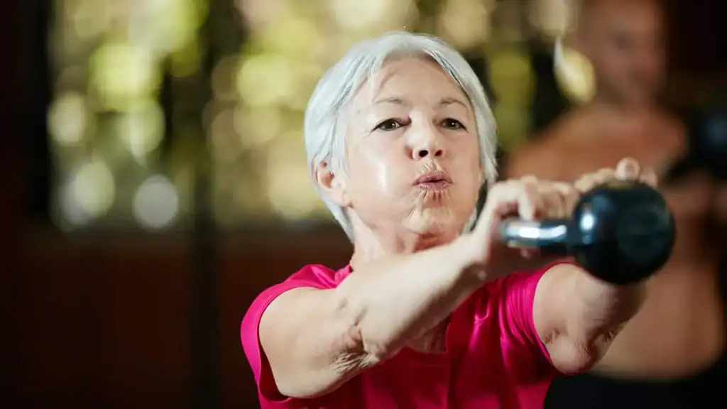 Older woman doing weight training Leeds to help her strength and longevity 