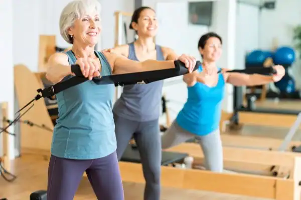 Toning Arms After 60: Empowering Womens Fitness Through Effective Weight Training 2 older woman doing weight training Leeds and resistance in the gym to tone upper arms