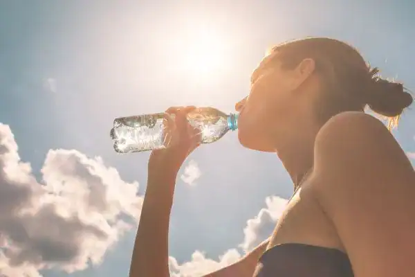 Hydration: The Secret Ingredient for a Toned Stomach and Enhanced Fitness 3 Image of woman drinking water to hydrate Leeds after run.